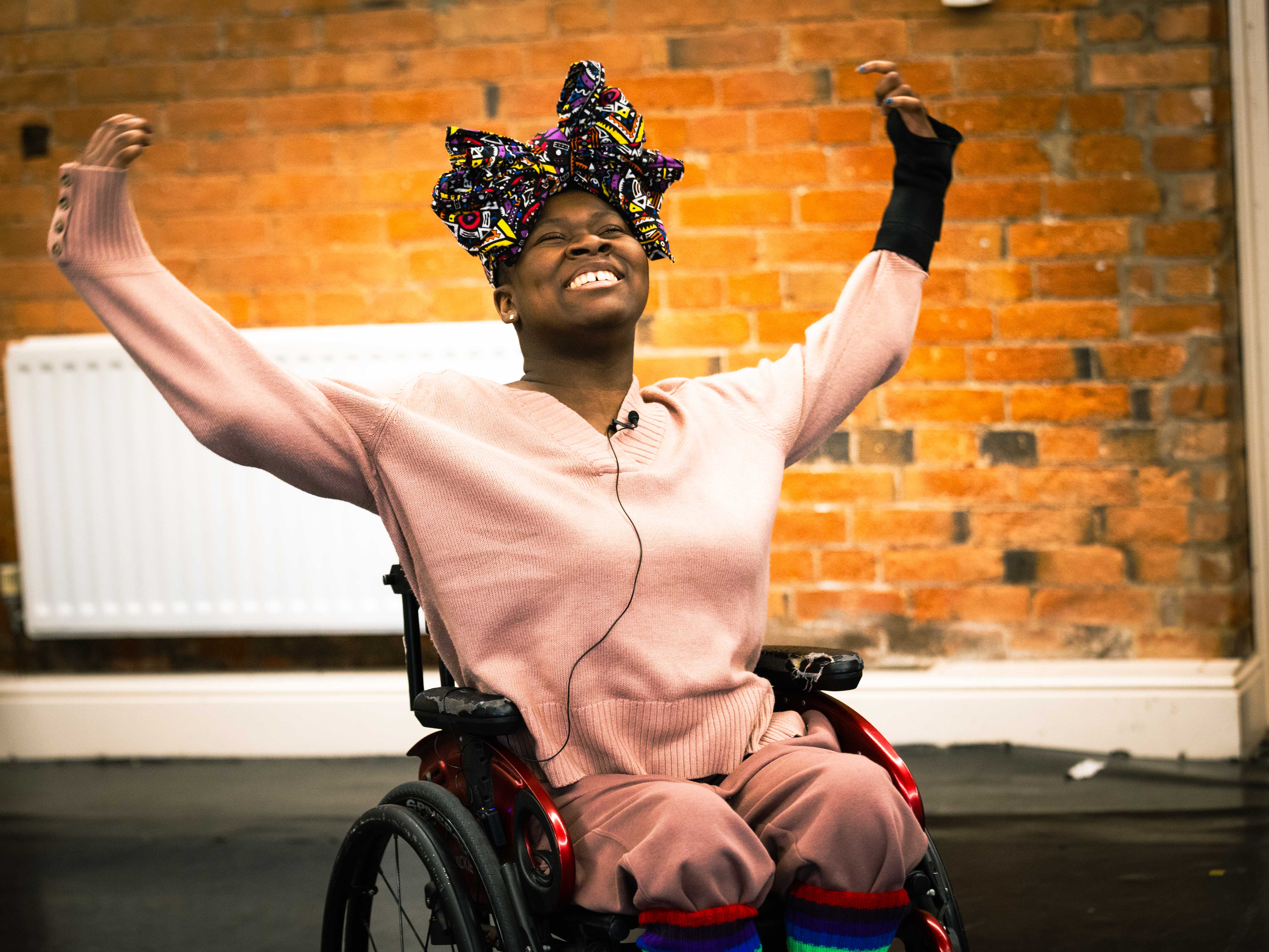 Performer smiling and holding their arms aloft in joy